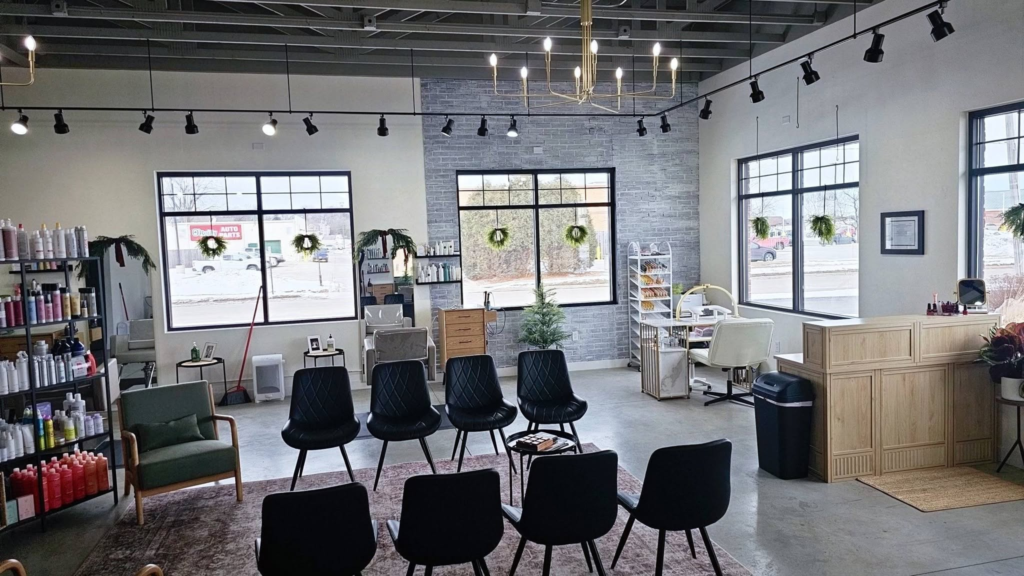 A bright, modern salon with styling chairs and holiday wreaths.