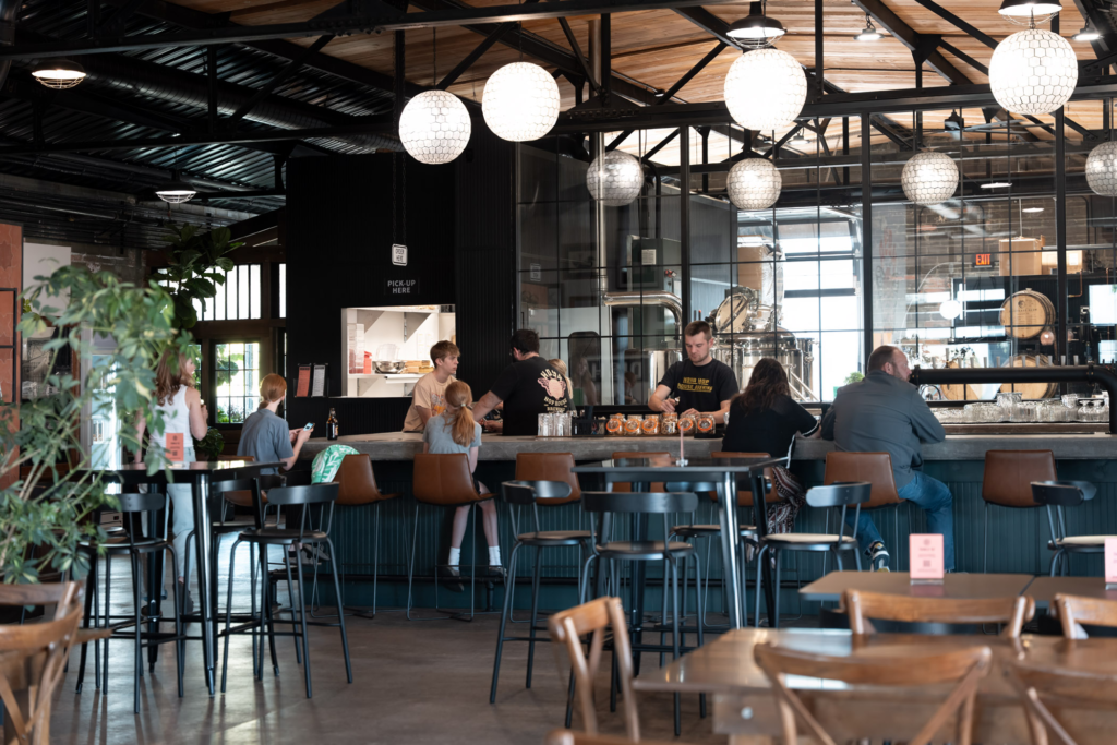 A cozy local taproom with tables and warm lights.