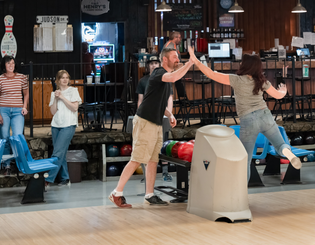 Friends celebrating a strike at Jud’s bowling alley.