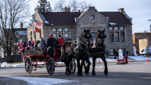 A horse-drawn carriage ride on a snowy day downtown.