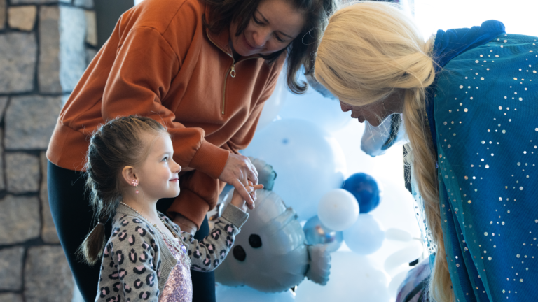 A little girl meeting a snow princess at a winter event.